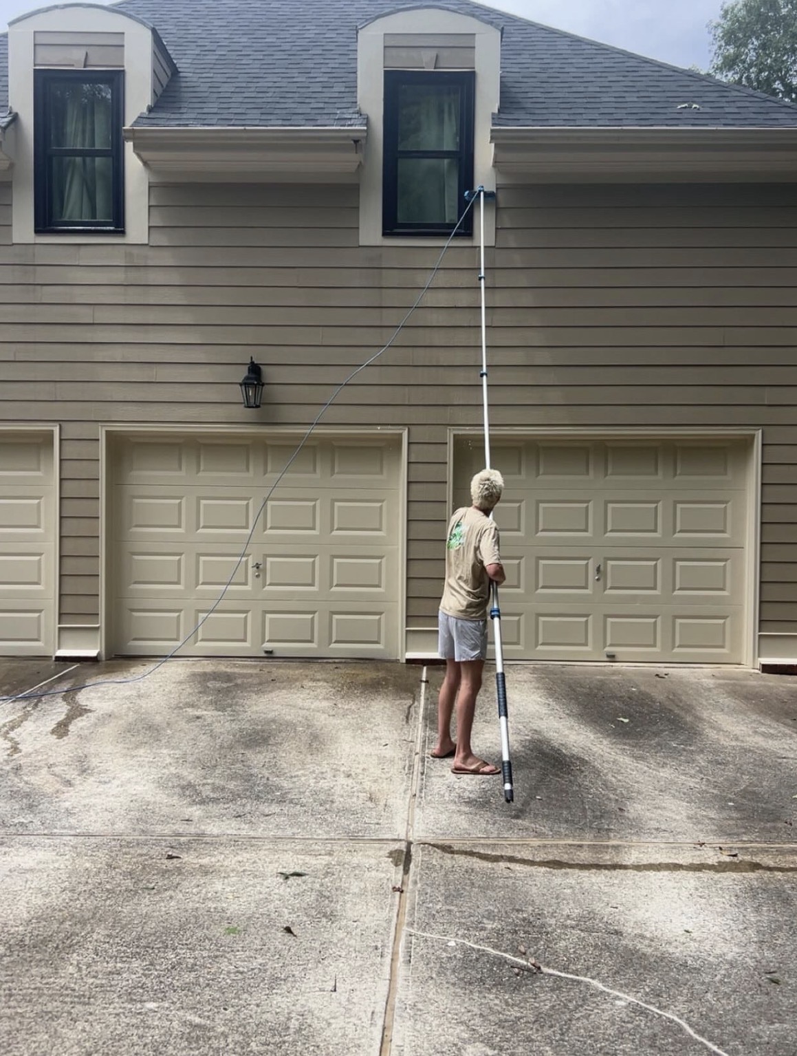 Window cleaner using a water-fed pole on a two-story home